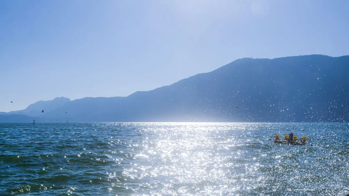 A sunlit lake and distant mountains in Kunming